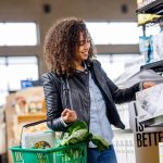 A woman carrying a grocery basket of vegetables