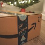Amazon delivery box with gifts in front of a Christmas tree