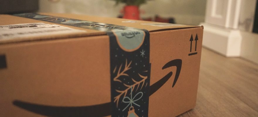 Amazon delivery box with gifts in front of a Christmas tree