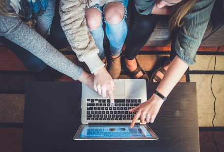 Three person pointing the silver laptop computer